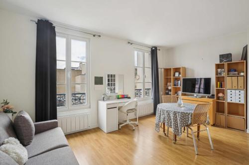 un salon avec une table et un canapé dans l'établissement L'Adorable, à Paris