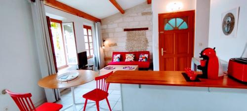 une cuisine avec une table et des chaises rouges dans une pièce dans l'établissement Proche Palais des Papes, à Avignon