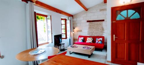 un salon avec un canapé rouge et une table dans l'établissement Proche Palais des Papes, à Avignon