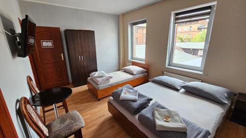 una piccola camera con due letti e una finestra di Apogeum Aparts a Piekary Śląskie