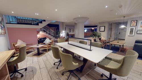 a living room with a table and chairs at Holiday Inn Cardiff City Centre by IHG in Cardiff