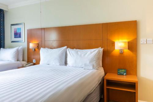 a hotel room with a large bed and two lamps at Holiday Inn Cardiff City Centre by IHG in Cardiff