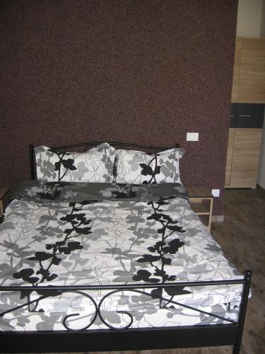 a bedroom with a bed with a black and white comforter at La Avocați in Vama Veche