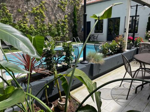 a patio with plants and a swimming pool at Demeures & Châteaux Le Pavillon d'Enghien, Vichy Centre in Vichy