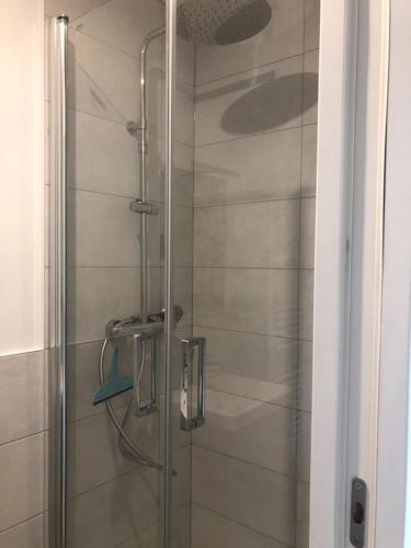une douche avec une porte vitrée dans une salle de bain dans l'établissement Studio maisonnette Caudan, à Caudan