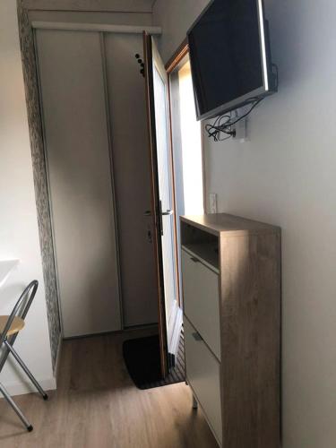 Cette chambre dispose d'une porte et d'une télévision murale. dans l'établissement Studio maisonnette Caudan, à Caudan