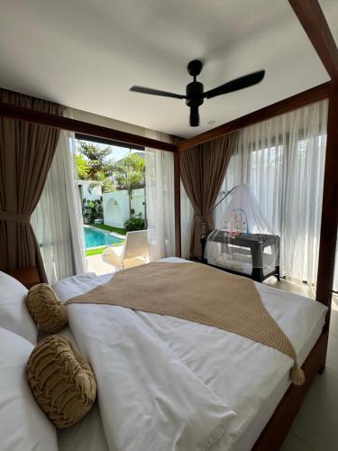 a bedroom with a large bed with a ceiling fan at Villa Anela in Puerto Princesa City