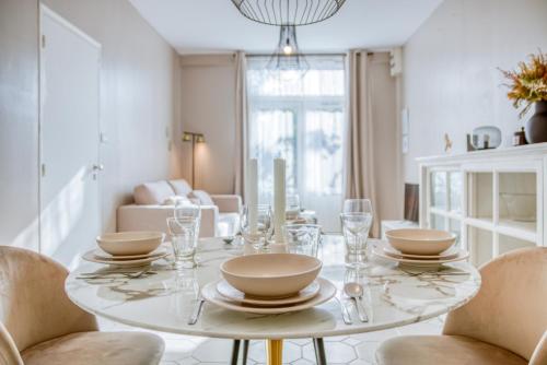 une salle à manger blanche avec une table et des chaises blanches dans l'établissement Douceur Flamande - Calme - Wifi, à Douai