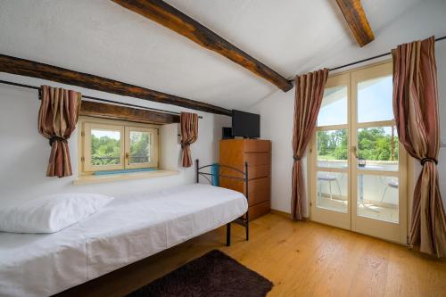 un dormitorio con una cama y una ventana en My Villa Ida with pool in Višnjan, Istria, en Štuti