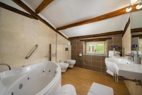 Un baño con dos lavabos, una bañera y un inodoro. en My Villa Ida with pool in Višnjan, Istria, en Štuti