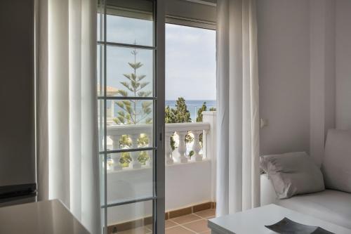 een woonkamer met een raam en een bank bij Ático el morche in Morche