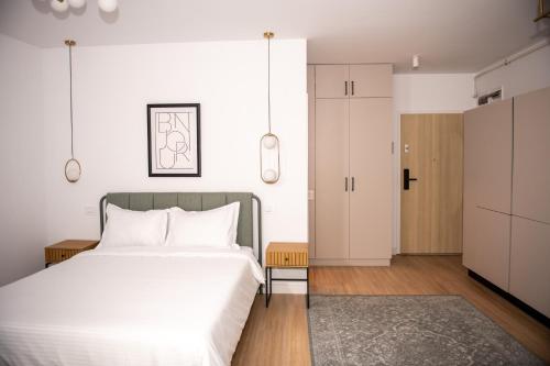 a bedroom with a large white bed and a closet at V25Appartments in Bucharest