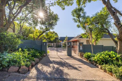 a gate in a yard with trees and plants at 1-on-Ross in Grahamstown