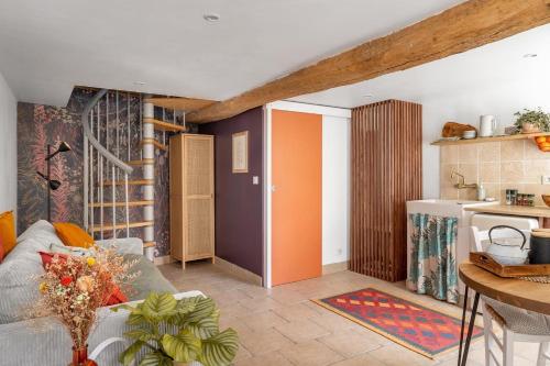 un salon avec un canapé et une cuisine dans l'établissement Petit Nid Champêtre, à Bouglainval