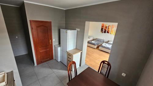 a kitchen and dining room with a refrigerator and a table at Apartamenty Piekary in Piekary Śląskie