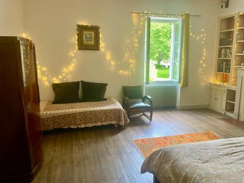 1 dormitorio con 2 camas y ventana con luces de Navidad en Chez Katia en Semur-en-Auxois