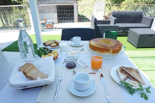 ein weißer Tisch mit Essen und einem Kuchen darauf in der Unterkunft Casale Mongiusti 1961 in Musano