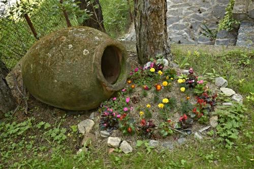 a large rock with flowers in front of a tree at Art Spa Villa Gal in Velingrad