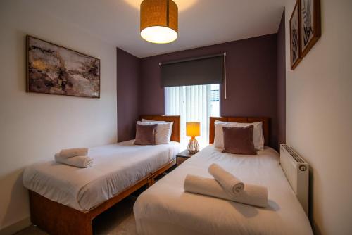 um quarto com 2 camas e toalhas em Spacious House Close to Royal Derby Hospital, Free Parking & Garden em Derby