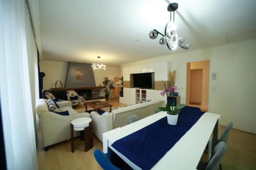 une cuisine et un salon avec une table et un canapé dans l'établissement Hébergement entier grande surface 7 adultes, à Franconville