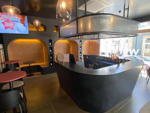 a restaurant with a bar with stools and tables at WOT Porto in Porto