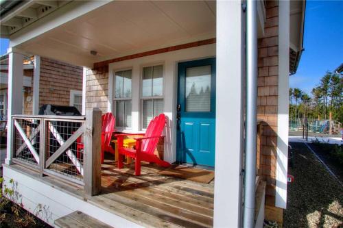 un porche con 2 sillas rojas y una puerta azul en The Chicken Coop by Seabrook Hospitality, en Pacific Beach