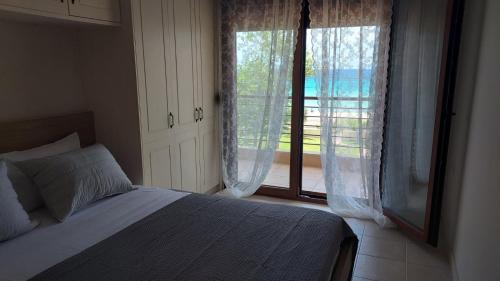 a bedroom with a bed and a large window at Villa Anna III in Nea Moudania