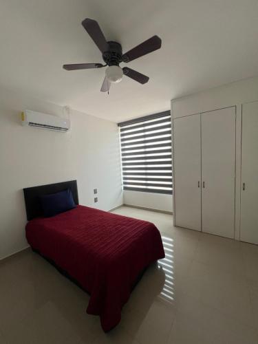 a bedroom with a red bed and a ceiling fan at Casa Samu in Tequila