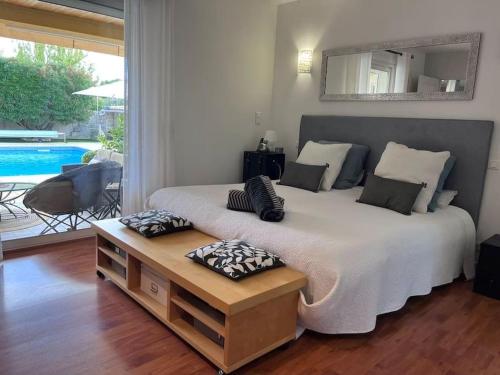 une chambre avec un grand lit avec des oreillers dessus dans l'établissement Belle villa avec piscine et spa, à Teyran