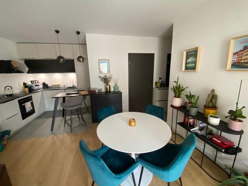 une cuisine avec une table blanche et des chaises bleues dans l'établissement La Scène du Lac - Au bord du Lac avec Garage, à Annecy