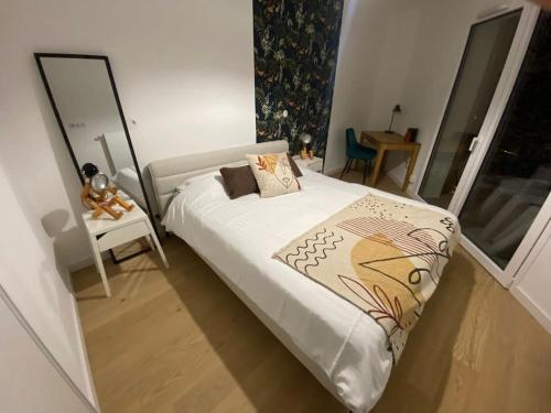 une petite chambre avec un lit et un miroir dans l'établissement La Scène du Lac - Au bord du Lac avec Garage, à Annecy