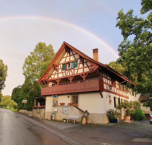a house with a rainbow in the sky at Studio beim Rhein - Ziegelhütte in Flaach