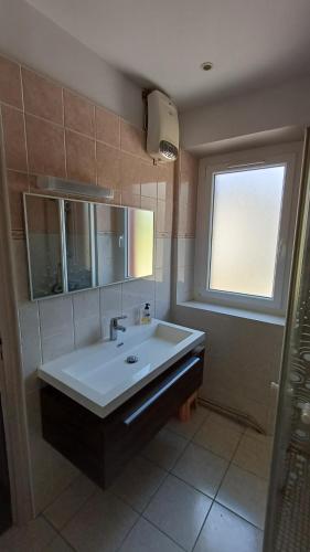La salle de bains est pourvue d'un lavabo, d'un miroir et d'une fenêtre. dans l'établissement Canta aoussel, à Moussoulens