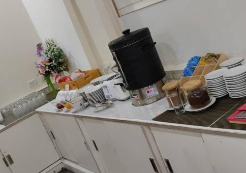 a kitchen counter with a coffee pot on top of it at โรงแรมวีวิช V Wish Hotel in Khon Kaen