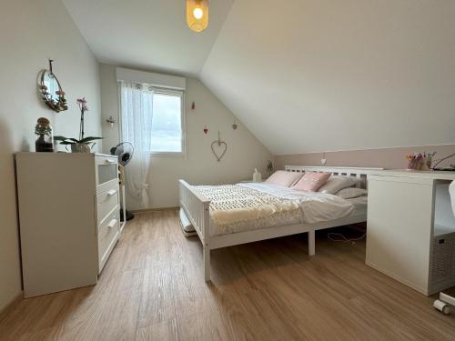 a bedroom with a bed and a dresser and a window at Maison La Belle Vigne avec jardin - Proche Obernai in Bernardswiller