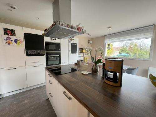 - une cuisine avec des appareils blancs et un comptoir en bois dans l'établissement Maison La Belle Vigne avec jardin - Proche Obernai, à Bernardswiller