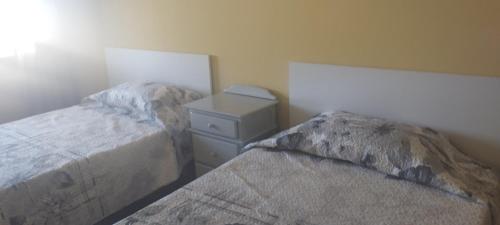 a bedroom with two beds and a night stand at Nuria's home in Calanda