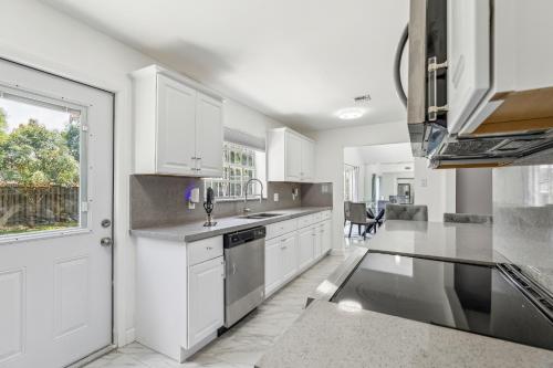 a kitchen with white cabinets and a window at Spacious 3BR Villa in Miami with Fenced Backyard in Miami