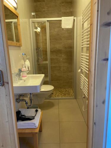 a bathroom with a sink and a shower at Landgasthof Kirchenwirt in Krimml