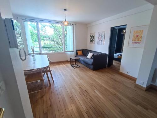 un salon avec un canapé et une table dans l'établissement À 5 min à pied de la gare, du tram et des Rives de l'Orne, à Caen