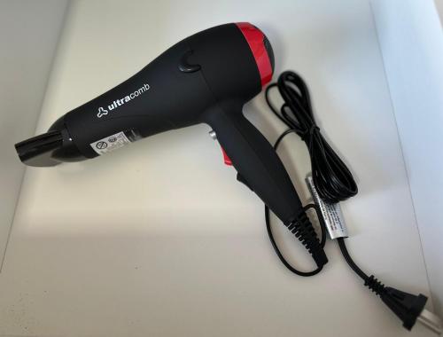 a black hair dryer sitting on a table at Rio Suits Apartments C in Posadas
