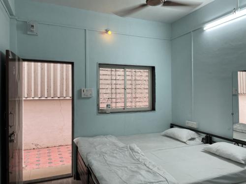 2 camas en una habitación con 2 ventanas en Fulgulab Lawns and Home Stay, en Junnar