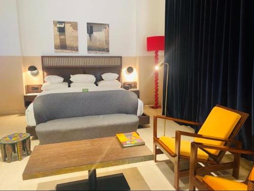sypialnia z łóżkiem, stołem i krzesłami w obiekcie Hotel Lepic w mieście Abidżan