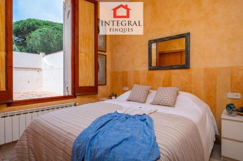 a bedroom with a bed and a window at Sal de Mar - Casa La Fosca in Palamós