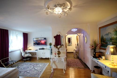 a living room with a chandelier and a table and a chair at Höckner Plaza Hotel in Attnang-Puchheim