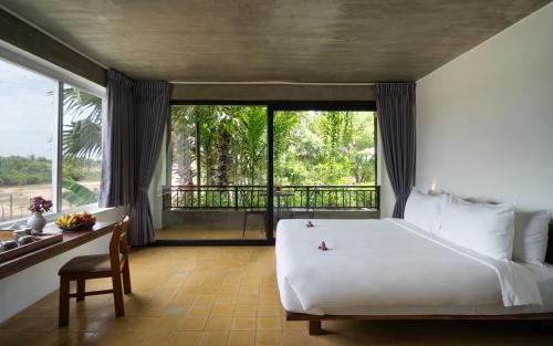 1 dormitorio con cama, escritorio y ventana en The Nature en Siem Riep