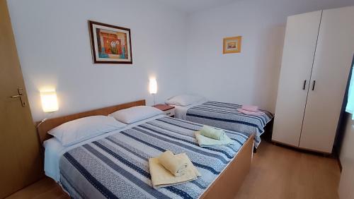 - 2 lits dans une petite chambre avec des serviettes dans l'établissement Apartment Miro, à Matulji