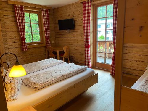 a bedroom with a bed in a room with windows at Landgasthof Kirchenwirt in Krimml