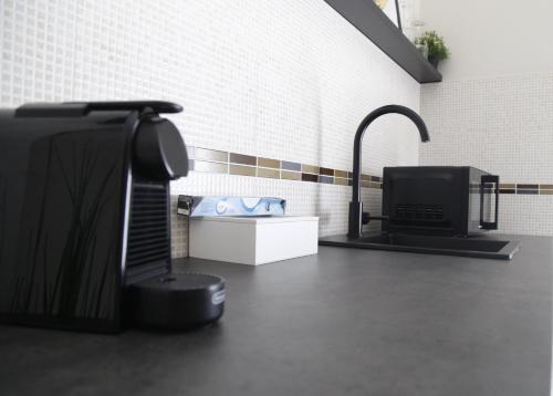 un bancone da cucina con TV e lavandino di Diverso Apartment a Caiazzo