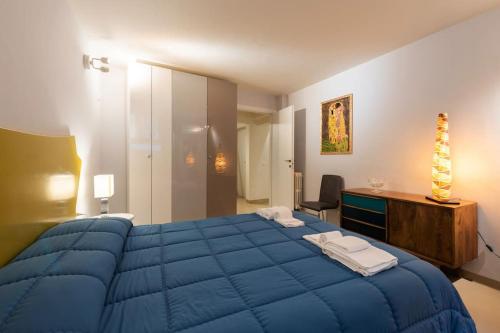 1 dormitorio con 1 cama azul grande y escritorio en Arch Apartment Duomo - Florence en Florence